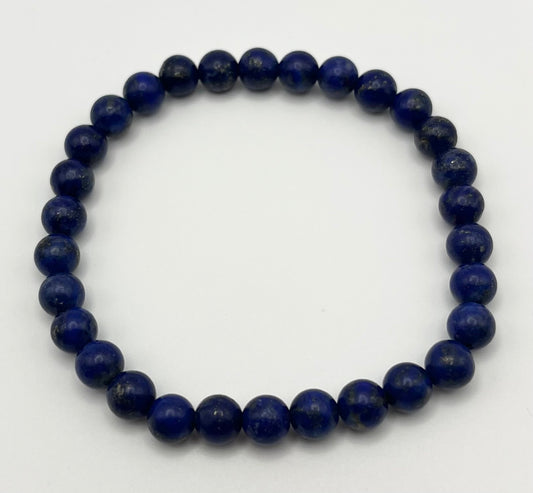 Blue beaded lapis lazuli gemstone bracelet on a white background